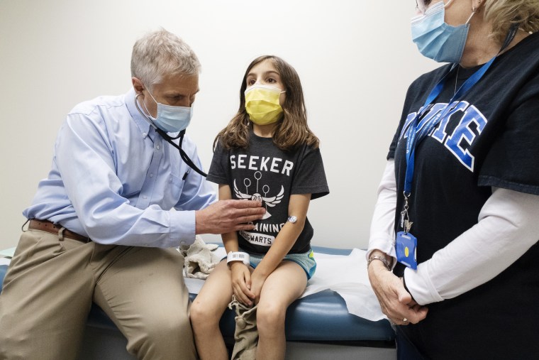 Dr. Emmanuel Walter checks Alejandra Gerardo, 9, before she receives the second of two Pfizer Covid vaccinations during a clinical trial for children at Duke Health.