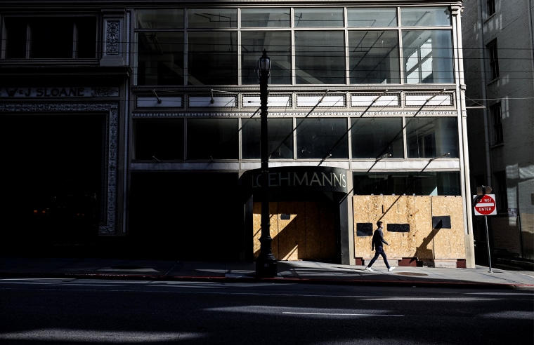 A pedestrian walks by a closed and boarded up business on April 16, 2021 in San Francisco.
