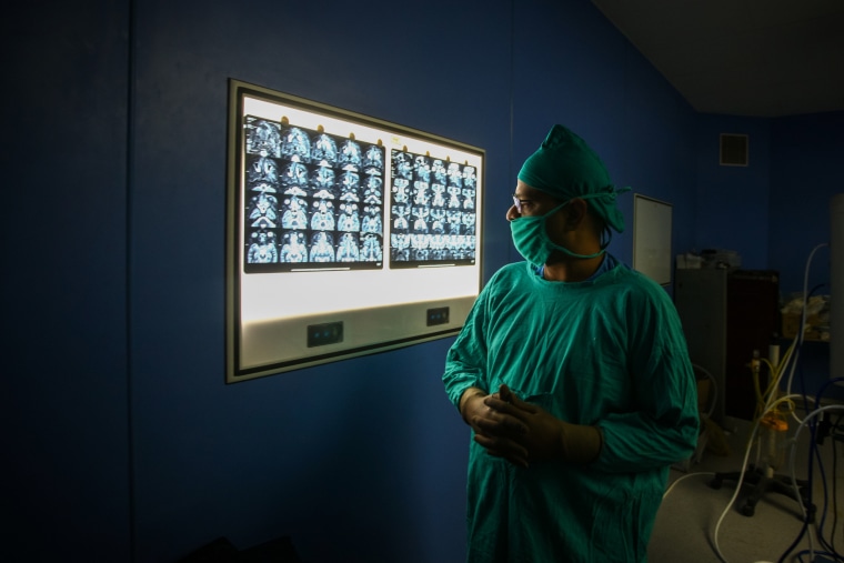 ALLAHABAD, INDIA - JUNE 05: Ear, nose and throat (ENT) specialist Dr. Sachin Jain checks an MRI report before performing surgery to remove mucormycosis, a rare but potentially deadly fungal infection, from a patient who recovered from Covid-19 at Swaroop Rani hospital on June 5, 2021, in Allahabad, India.