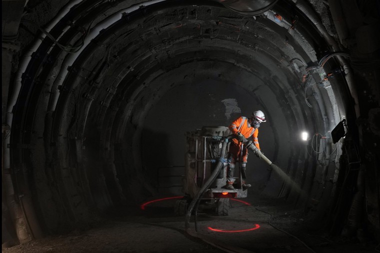 A worker sprays a layer of cement protection in a tunnel for radioactive waste in an underground laboratory run by Andra, an agency that manages the waste, in Bure, eastern France, on Oct. 28, 2021.