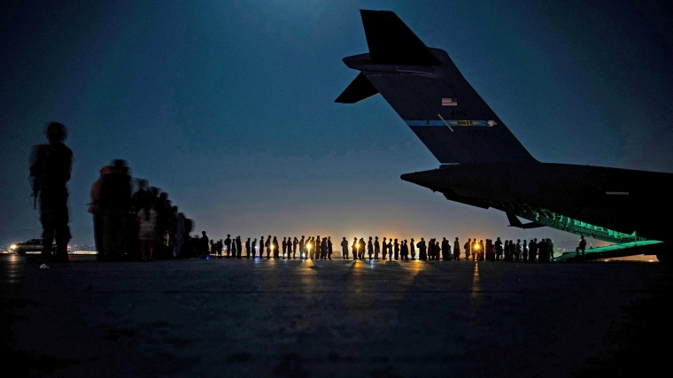 Evacuees board a U.S. Air Force C-17 Globemaster III at Hamid Karzai International Airport in Kabul, Afghanistan, on Aug. 20, 2021.