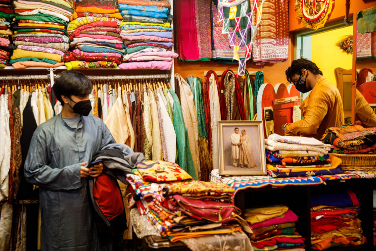 Vidur Bahl, left, and Yaman Walia try on kurtas at Dress Shoppe II, an Indian clothing boutique on the Lower East Side in New York, on Nov. 4, 2021.
