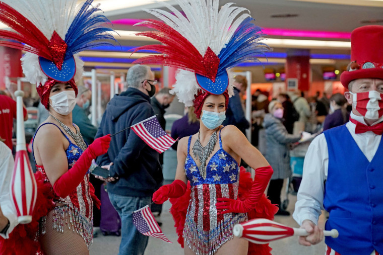 Personas disfrazadas entretienen a los viajeros en el aeropuerto londinense de Heathrow cuando Estados Unidos reabre sus fronteras a los visitantes del Reino Unido y otros países.