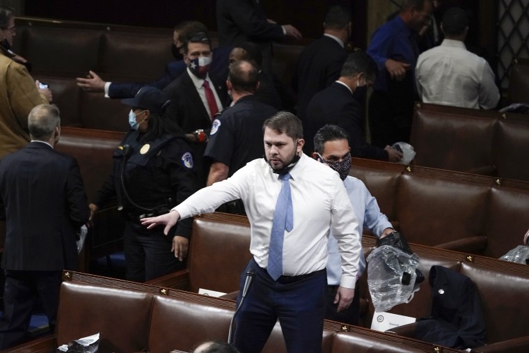 Rep. Ruben Gallego, D-Ariz., climbs on a chair and shouts to his colleagues to make sure they are aware of plans to evacuate the floor as rioters try to break into the House Chamber at the Capitol on Jan. 6, 2021