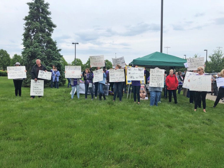 A crowd carrying signs protesting SEL gathers ahead of the Carmel Clay School Board meeting on May 17, 2021.