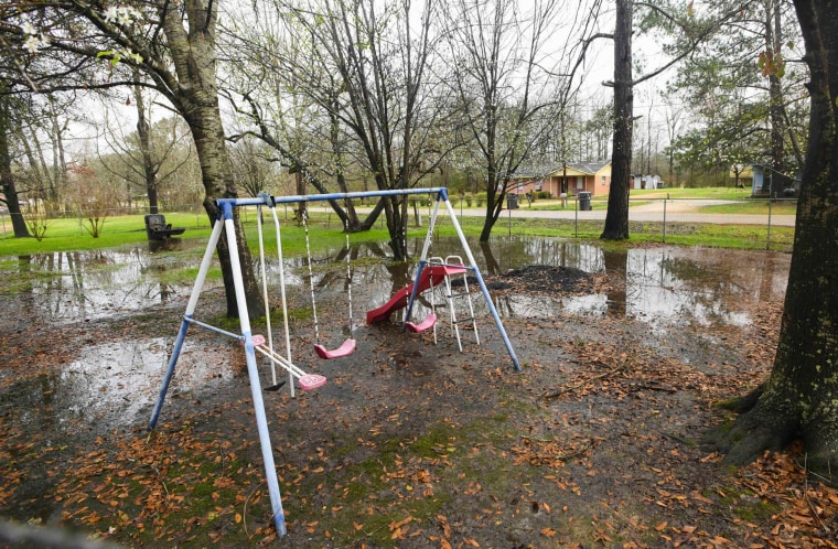 Heavy rains flood the front yard of Charlie Mae Holcombe, with water pooling around a plastic swing set