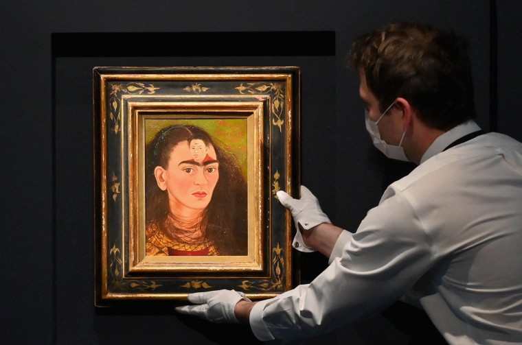 Image: An art handler adjusts Frida Kahlo's final "Bust" Self-Portrait 'Diego y yo" at Sotheby's on Nov. 5, 2021 in New York City.