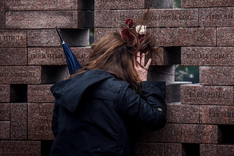 Image: A woman at the memorial wall during the 20th annual Flight 587 service in Belle Harbor, Queens, N.Y., on Nov. 12, 2021.