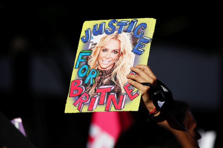 A supporter of Britney Spears holds up a picture of the pop star with the words "Justice for Britney" during celebrations for the termination of her conservatorship outside the Stanley Mosk Courthouse in Los Angeles on Nov. 12, 2021.