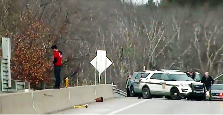 Christian Hall stands on a ledge on a highway overpass on Dec. 30, 2020. 