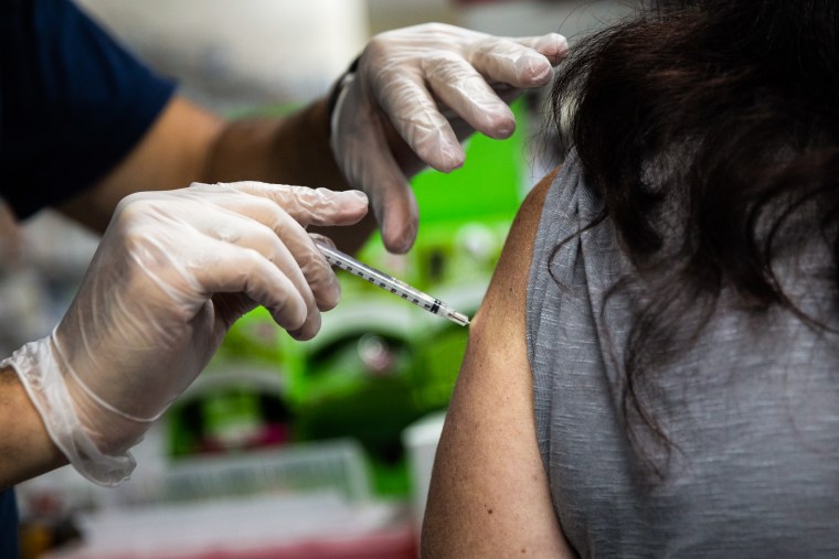 A pharmacist administers a third dose of the Moderna Covid-19 vaccine to a customer at a pharmacy in Livonia, Mich., on Aug. 17, 2021.