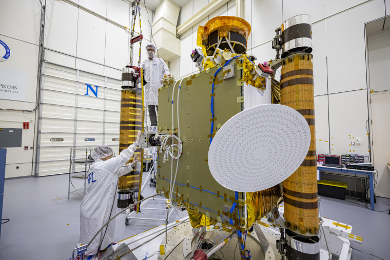 DART team members perform a final inspection of one of the spacecraft's two roll-out solar arrays in August 2021.