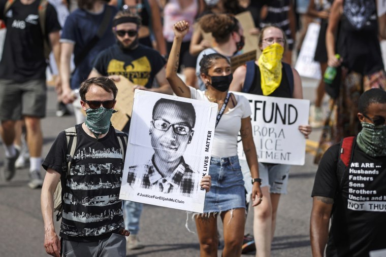 Demonstrators walk down Sable Boulevard during a rally and march over the death of Elijah McClain in Aurora, Colo., on June 27, 2020.