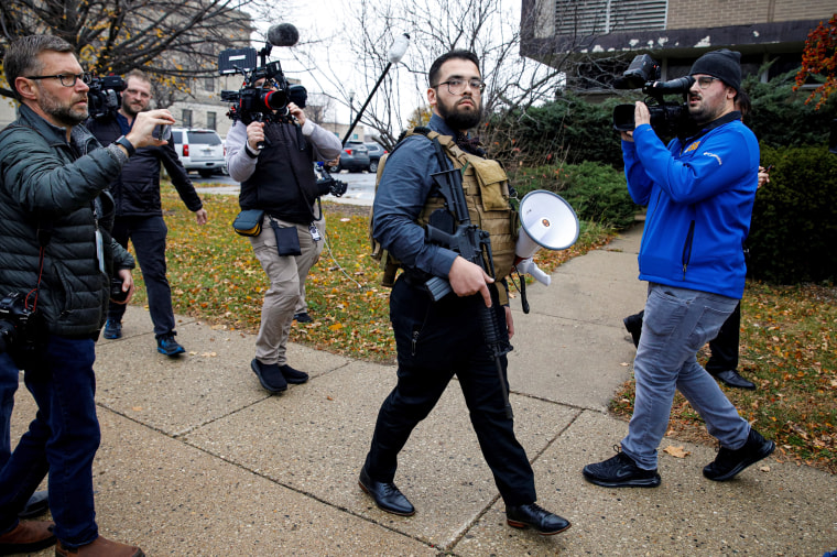 Image: A protester who called himself Maserati Mike carries an assault style rifle outside the Kenosha County Courthouse, during the trial of Kyle Rittenhouse, in Kenosha, Wisconsin