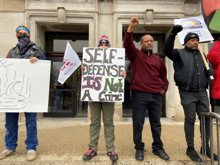 Kyle Rittenhouse supporter Emily Cahill holds a sign outside of the Kenosha County courthouse on Nov. 17, 2021.