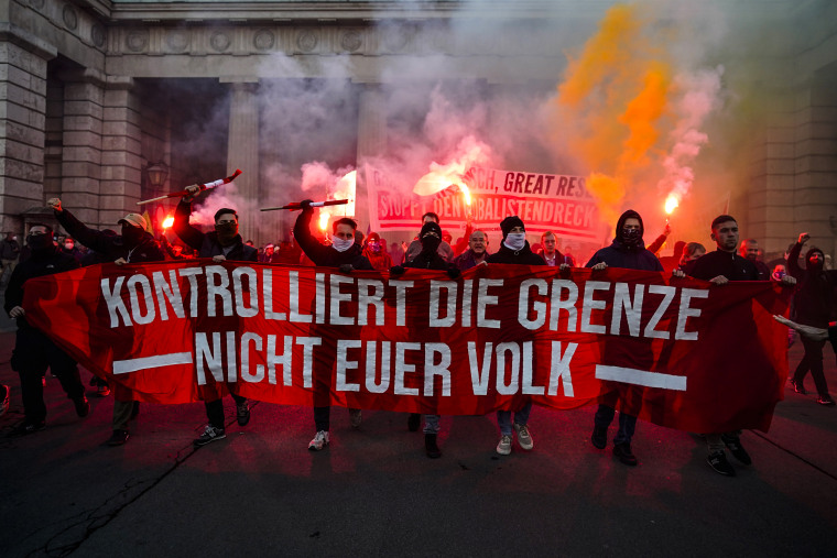 Image: Demonstrators shout slogans and light flares during a demonstration against measures to battle the coronavirus pandemic in Vienna on Nov. 20, 2021.