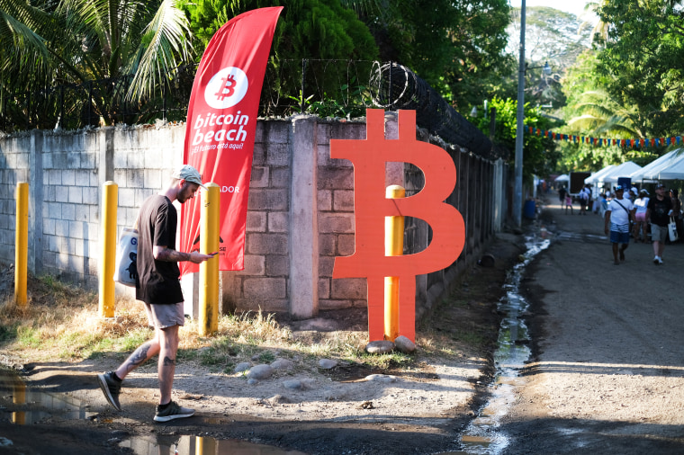 A man walks by a Bitcoin sign in Chiltiupan, El Salvador, on Nov. 18, 2021.