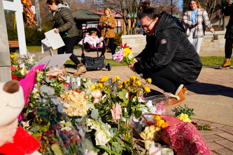 Alexandera Cimbalnik lays flowers at a memorial at Veterans Park after a car plowed through a holiday parade in Waukesha, Wis., on Nov. 23, 2021.