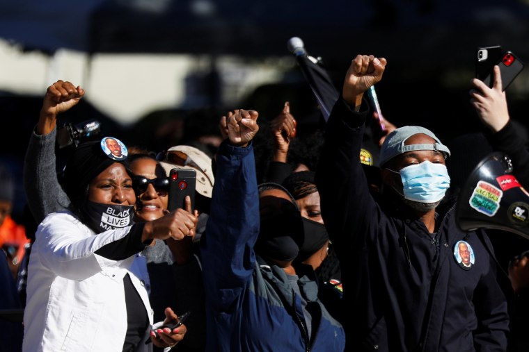 People raise their fists outside the Glynn County Courthouse after the jury reached a guilty verdict in the trial of William "Roddie" Bryan, Travis McMichael and Gregory McMichael, charged with the February 2020 death of 25-year-old Ahmaud Arbery, in Brunswick, Ga., on Nov. 24, 2021.