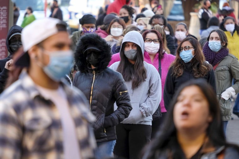 Black Friday shoppers wearing face masks wait in line to enter a store at the Citadel Outlets in Commerce, Calif., Friday, Nov. 26, 2021.