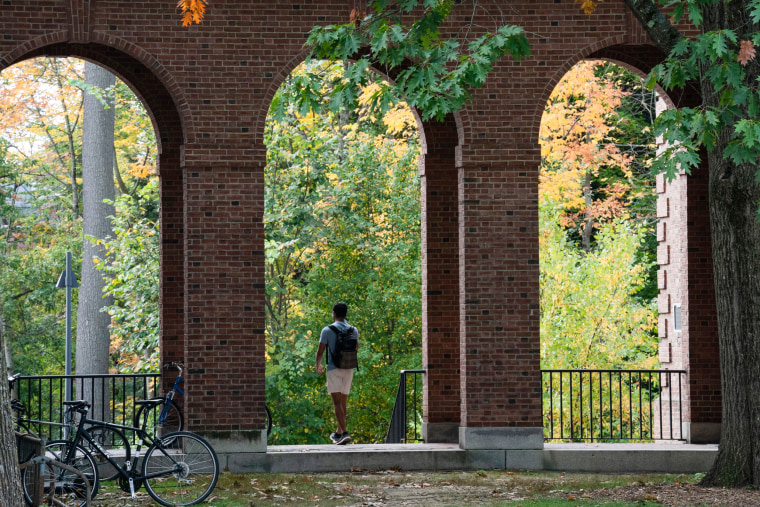 A student walks between dormitory buildings on the campus of Dartmouth College in Hanover, N.H., on Oct. 15, 2021.