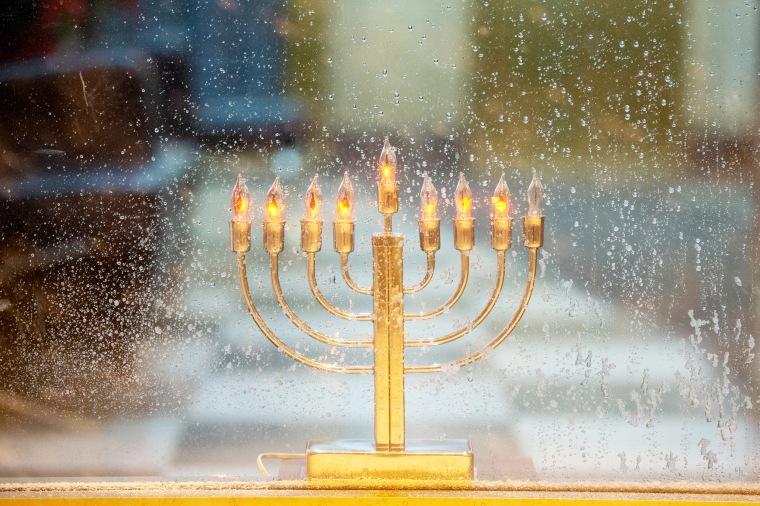 A menorah is displayed in a window on the seventh night of Hanukkah during a snow storm  on Dec. 16, 2020, in New York.