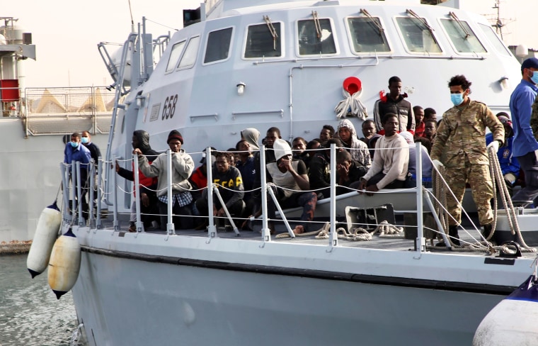 Migrants sit on the deck of a Libyan Coast Guard ship in Tripoli, Libya, on April 29, 2021.