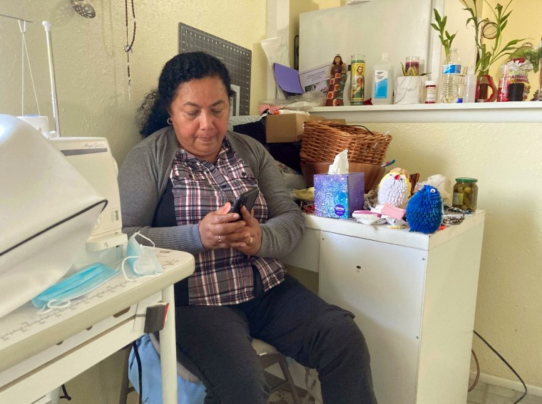 Rosalidia Dardon looks at a picture of her daughter in El Salvador as she sits in a refugee house in Texas, awaiting asylum or a protected immigration status on Nov. 4, 2021.