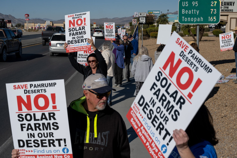 Attendees hold signs at a rally to protest solar development in Pahrump, Nev., on Nov. 27, 2021.