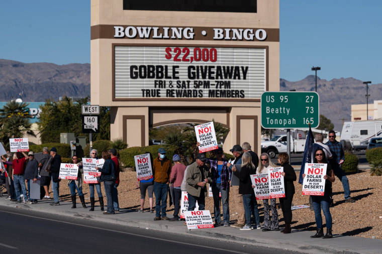 Attendees hold signs at a rally to protest solar development in Pahrump, Nev., on Nov. 27, 2021.