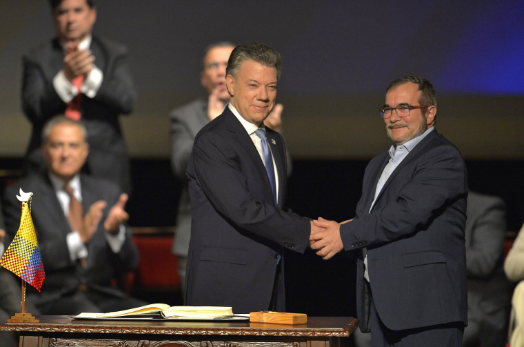 Then Colombian President Juan Manuel Santos and Timoleon Jimenez, aka Timochenko, the head of FARC, shake hands during the second signing of the historic peace agreement in Bogota, Colombia, on Nov. 24, 2016.