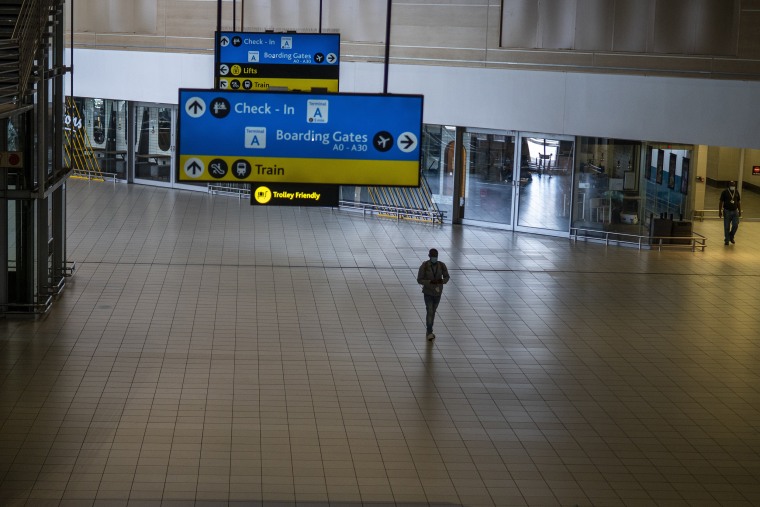 Image: A man walks through a deserted part of O.R. Tambo airport in Johannesburg, South Africa, on Nov. 29, 2021. The World Health Organization urged countries around the world not to impose flight bans on southern African nations due to concern over the new omicron variant.