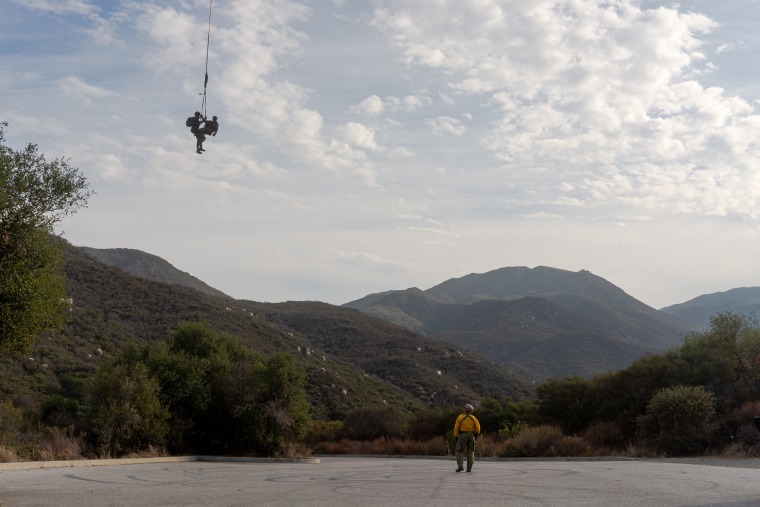Image: A helicopter transports part of the crew from the Cleveland National Forest to a nearby parking lot.
