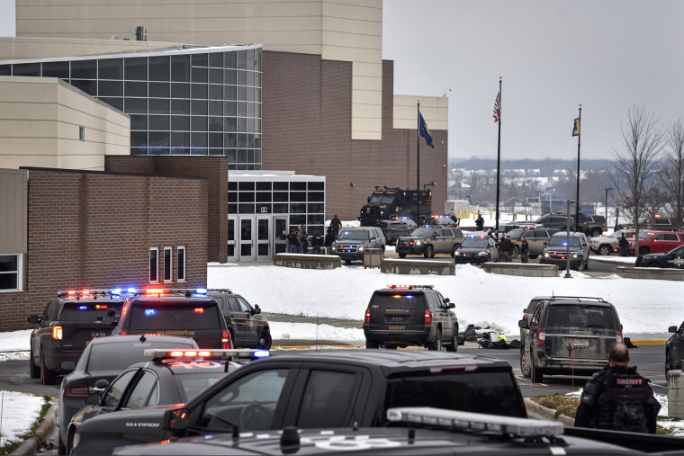 Image: Dozens of police, fire, and EMS personnel work on the scene of a shooting at Oxford High School on Nov. 30, 2021, In Oxford Township, Mich.