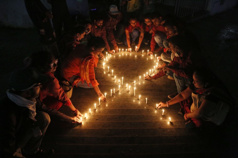 Image: People arrange candles in the shape of a ribbon, the symbol of awareness and support for those living with HIV, on the eve of World AIDS day in Ahmedabad, India, on Nov. 30, 2021.