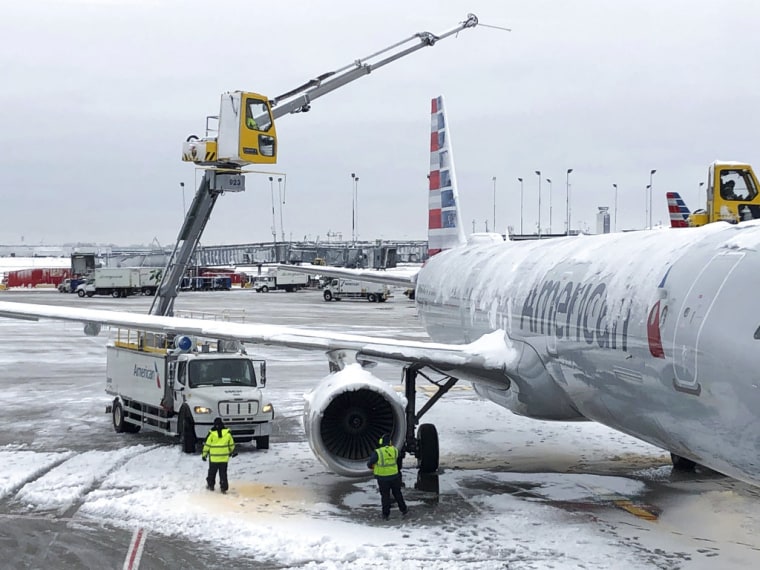Operarios del aeropuerto internacional O'Hare de Chicago intentan deshacer con una máquina las placas de hielo en un avión, el 26 de noviembre de 2018.