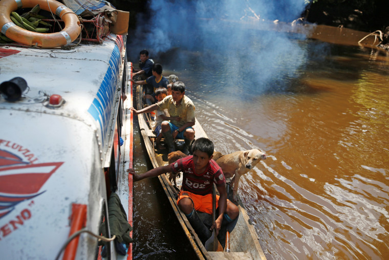 Un grupo de indígenas peruanos se acercan a un barco cargado con vacunas contra el COVID-19.