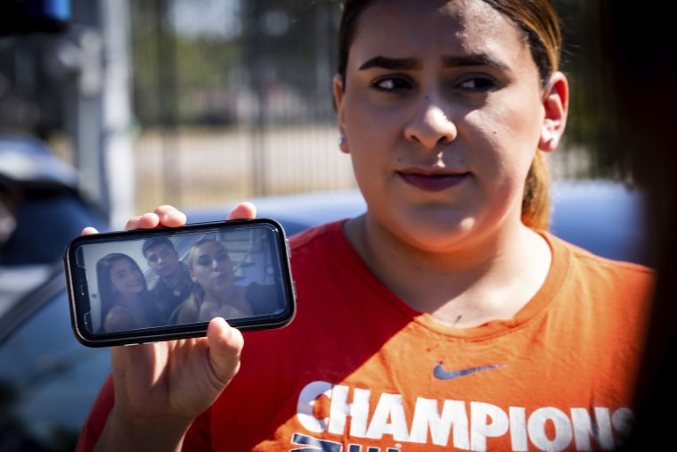 Stacey Sarmiento sostiene una foto de ella posando con su amigo, Rudy Peña, quien murió en el festival de música Astroworld en Houston.