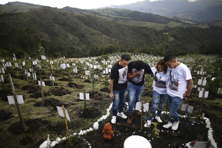 Familiares de Luis Enrique Rodríguez, quien falleció por COVID-19, visitan el cementerio en la reserva natural de El Pajonal, Colombia