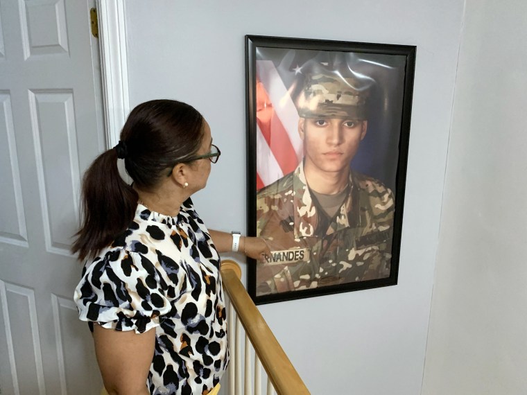 Ailina Fernandes mira una foto de su hijo Elder en un pasillo de casa.