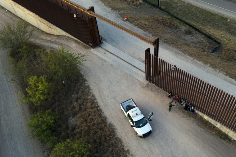 Un agente de la Patrulla Fronteriza habla con los migrantes después de ser detenidos y puestos bajo custodia, el 21 de marzo de 2021, en Abram-Perezville, Texas.