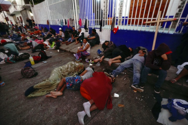Migrantes centroamericanos descansan en la calle en Huixtla, en el estado mexicano de Chiapas, en su camino hacia Estados Unidos, el 26 de octubre de 2021.