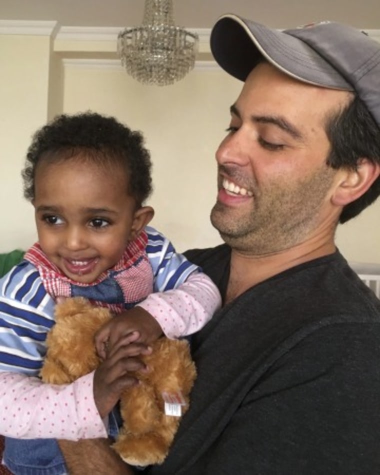 Ben Pascal y su hija Naomi, cuando fue adoptada en Etiopía. La pequeña sujeta en sus manos el famoso peluche 'Teddy'.