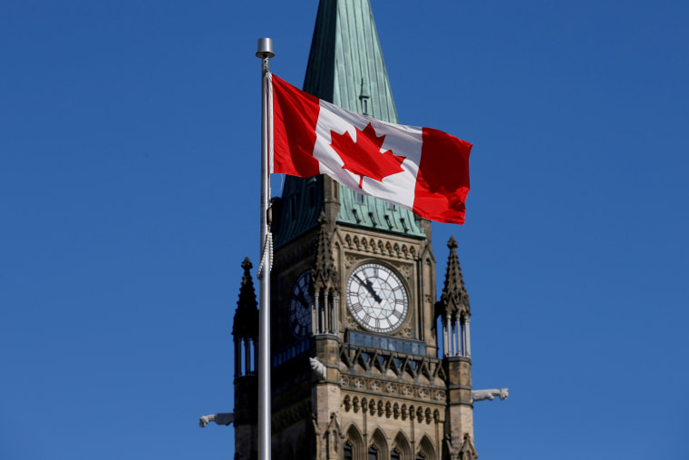 Una bandera canadiense ondea frente a la Peace Tower de Ottawa, Canadá