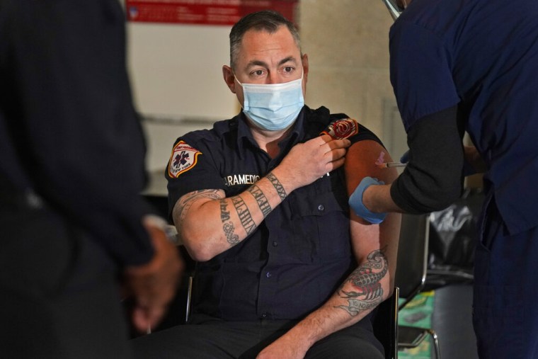 Un bombero de Nueva York recibe una dosis de la vacuna contra el COVID-19.
