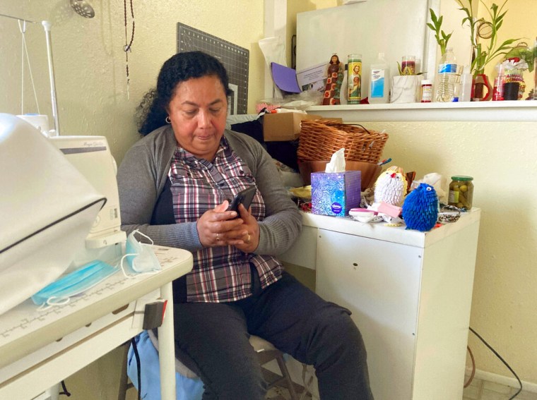 Rosalidia Dardon, de 54 años, mira una foto de su hija en El Salvador mientras está sentada en una casa de refugiados en Texas, a la espera de asilo o de un estatus migratorio protegido el 4 de noviembre de 2021.