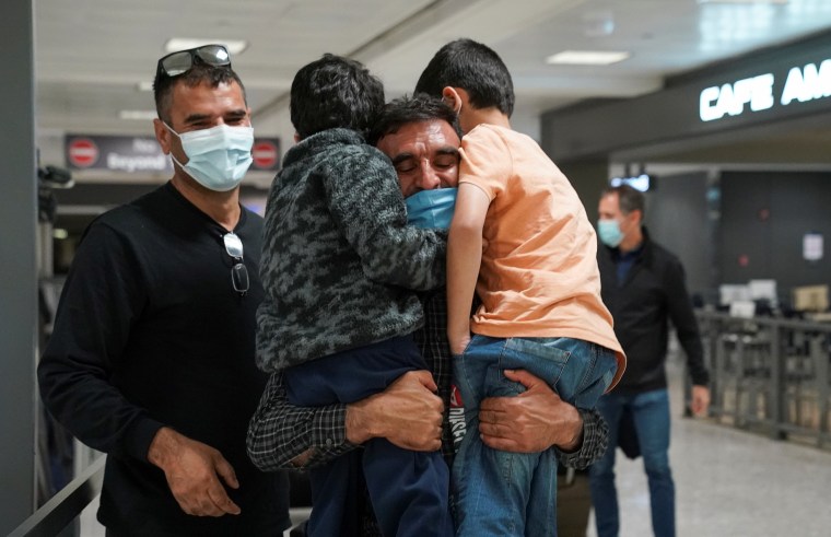 Abdul Shukoor abraza a sus sobrinos mientras se reúnen a su llegada de Bruselas al aeropuerto internacional de Dulles en Chantilly, Virginia.