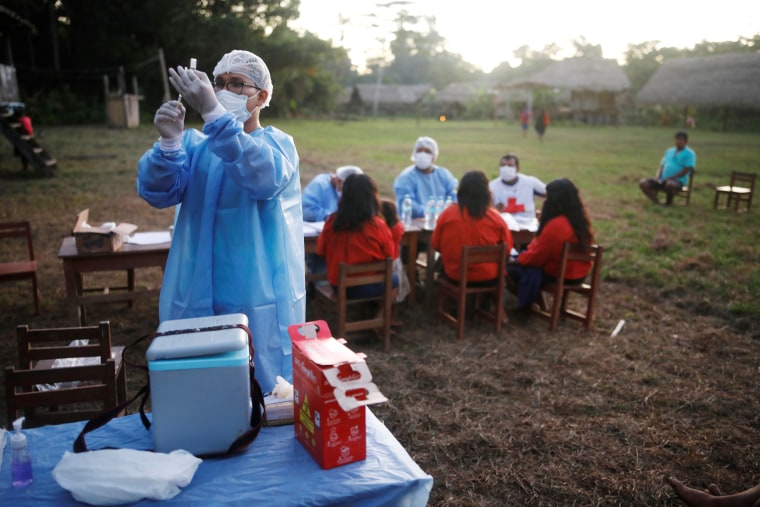 El enfermero Diego Sánchez prepara una vacuna contra el COVID-19 para ser administrada a un habitante de una aldea remota de la Amazonia peruana.