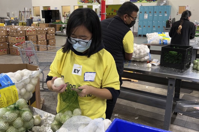 A volunteer packs onions in the warehouse of the Alameda County Community Food Bank in Oakland, Calif., on Nov. 5, 2021.