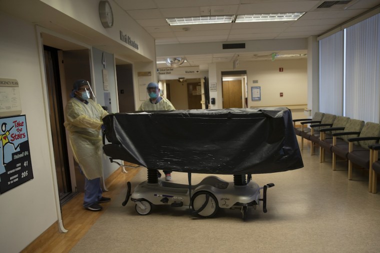 Trabajadores hospitalarios trasladan el cuerpo de una víctima del COVID-19 en el centro médico Saint Jude en Fullerton, California, el 7 de julio del 2020. La pandemia redujo la esperanza de vida en EEUU en 1.5 años.